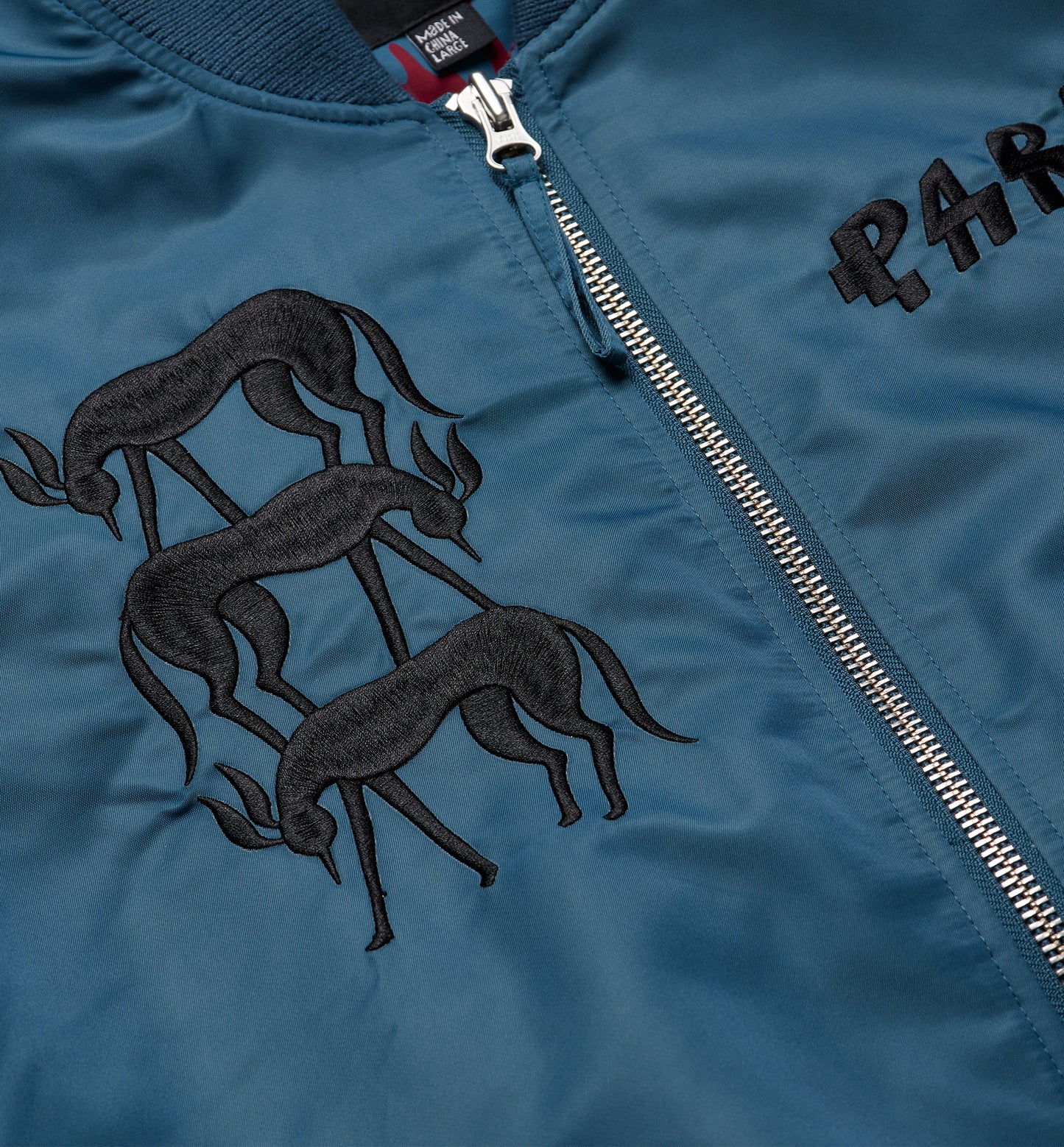 By Parra Stacked Pets Varsity Jacket Teal